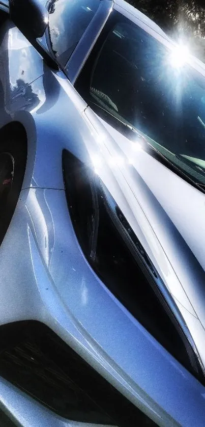 Sleek silver sports car with sunlight reflection on a sunny day.