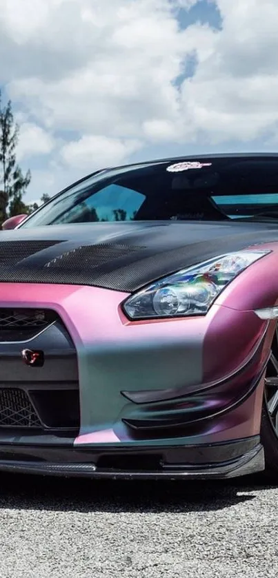 Sleek sports car with glossy pink finish under a bright sky.