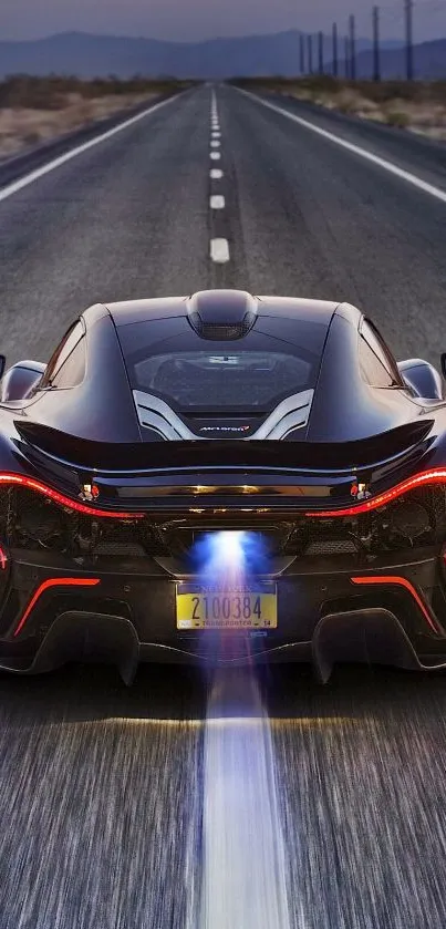 Sleek sports car driving down an open highway at night.