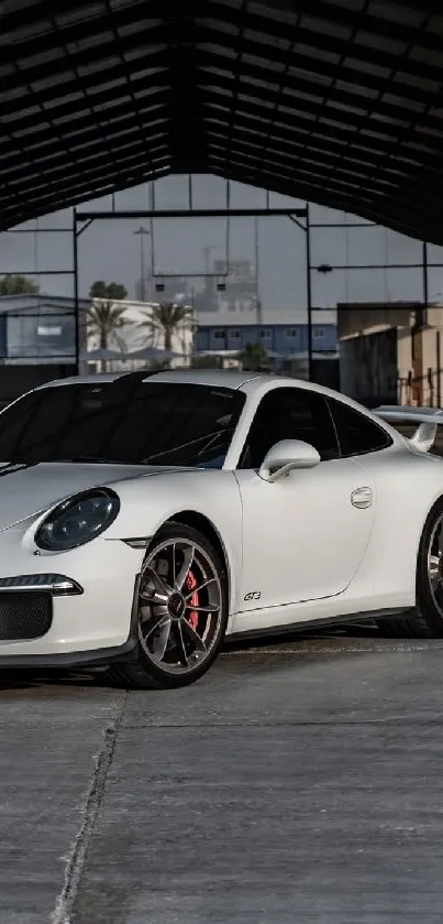 White sports car parked inside industrial building.