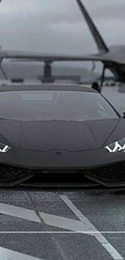 Sleek black sports car with jets on a runway.