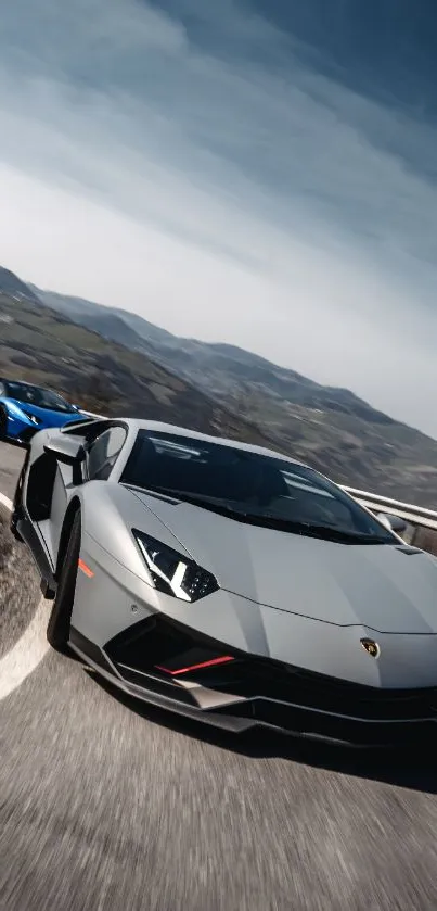 Sleek sports cars driving on a curving mountain road.