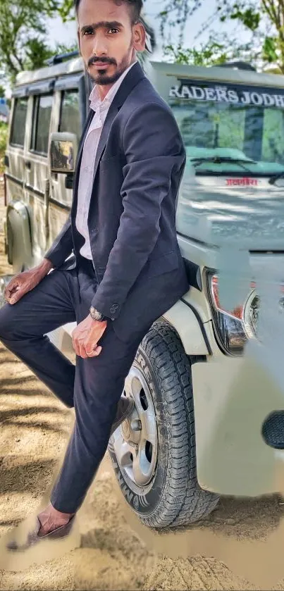 Man in suit leaning on SUV with trees in the background.