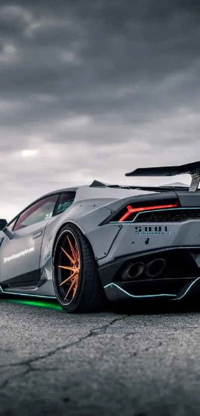 Sleek supercar on open road under dramatic skies.