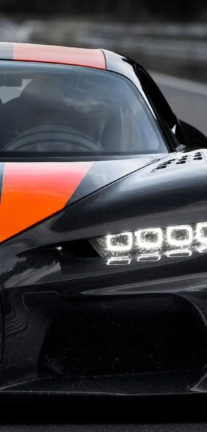 Sleek black sports car with orange racing stripes on the road.