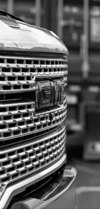 Close-up of a truck's chrome grille in monochrome, highlighting sleek design.