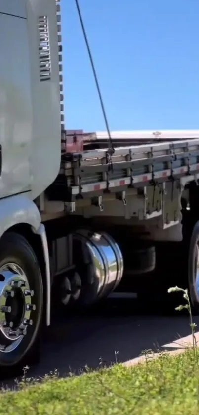 Sleek white truck on an open highway under a clear blue sky.