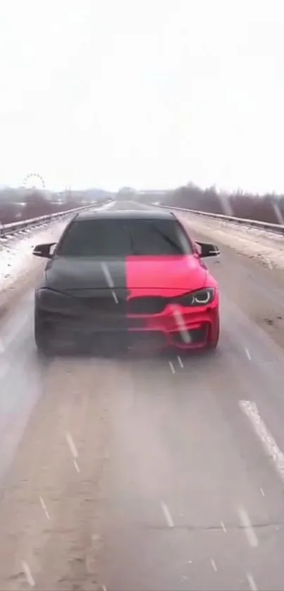 A sleek two-tone red and black car driving on a snowy road.