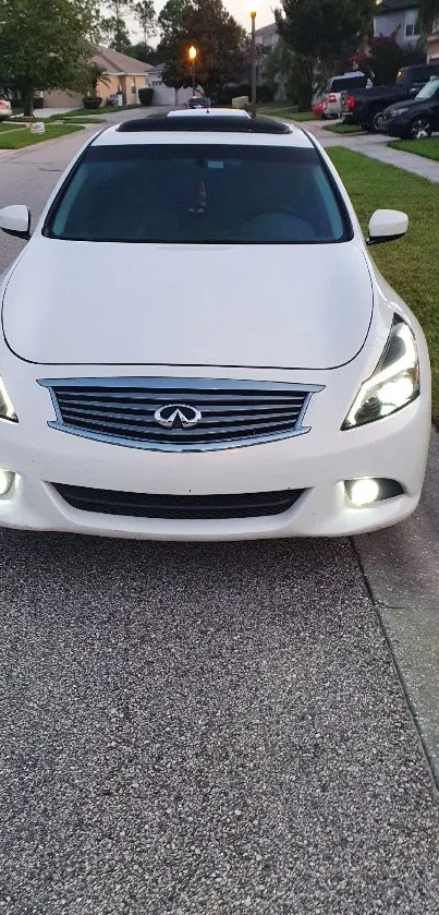 Sleek white car on a suburban street, front view.