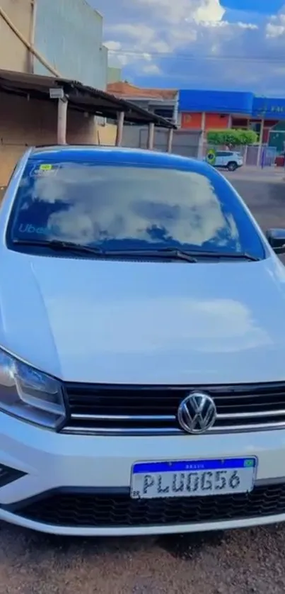 Sleek white car with sky reflection on windshield.