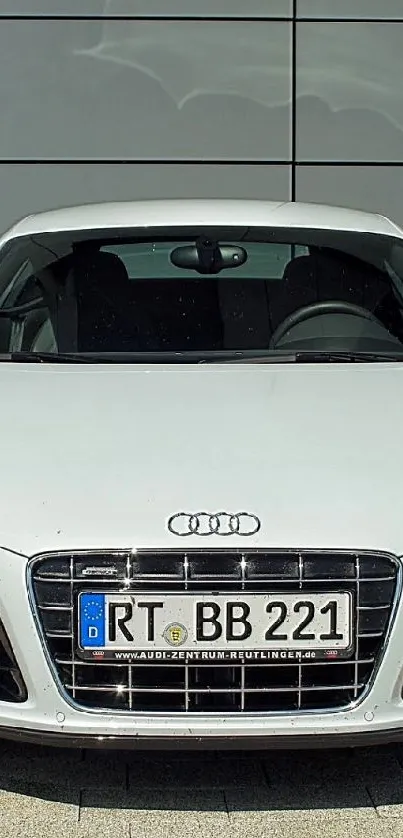 Sleek white luxury car parked outdoors.