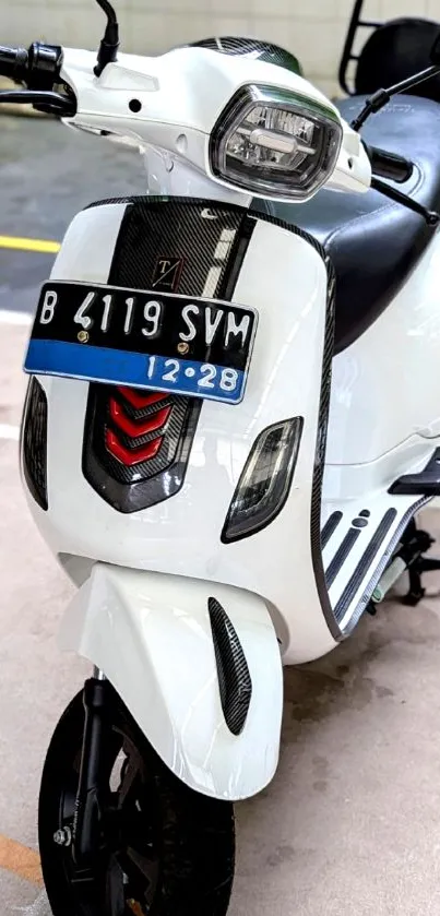 Sleek white scooter parked on pavement.