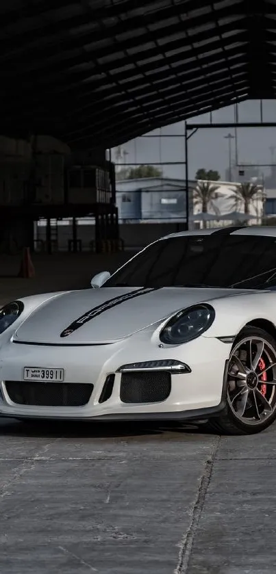 A sleek white sports car in an industrial setting.