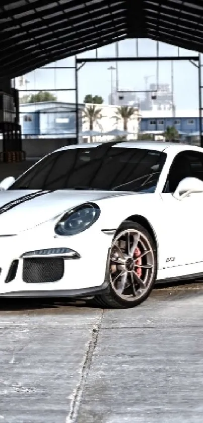 White sports car in spacious industrial area.