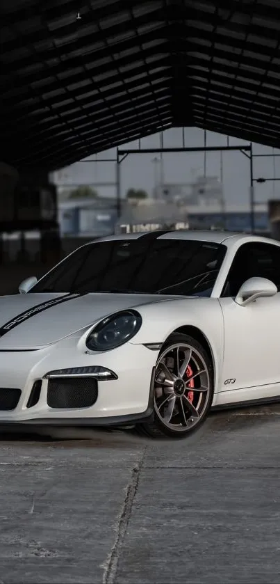 Sleek white sports car in an industrial setting.