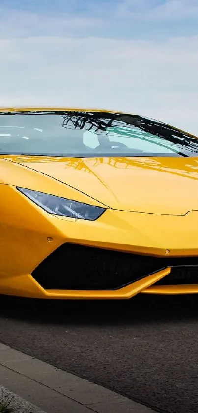 Yellow sports car parked on roadside under blue sky.