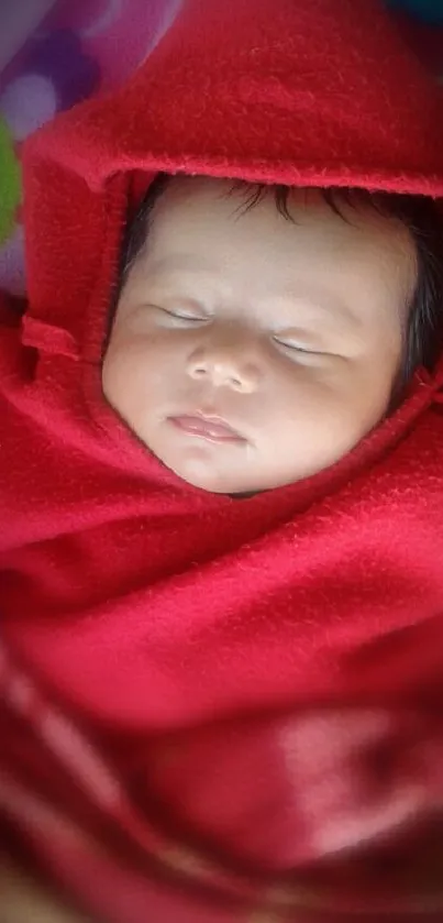 Sleeping baby wrapped in a red blanket.