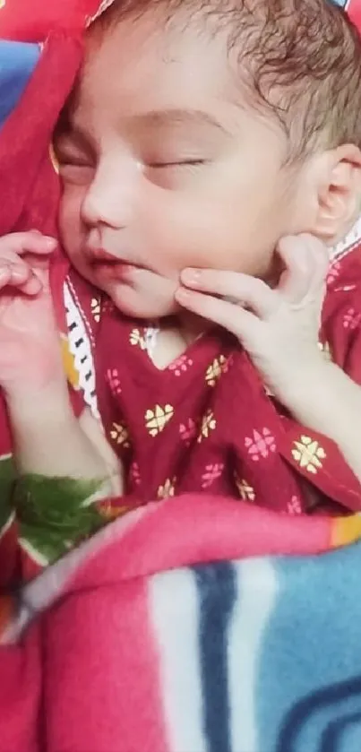 Sleeping baby wrapped in a colorful blanket.