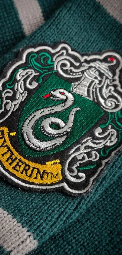 Slytherin crest on green knitted fabric.