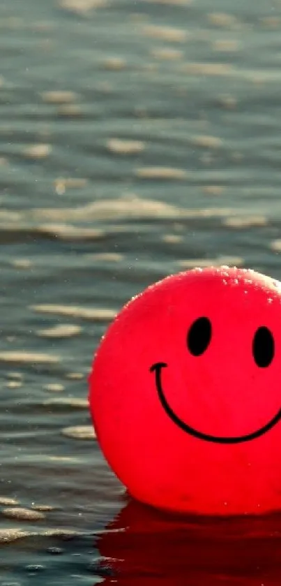 Pink smiley beach ball floating in ocean waves at sunset.