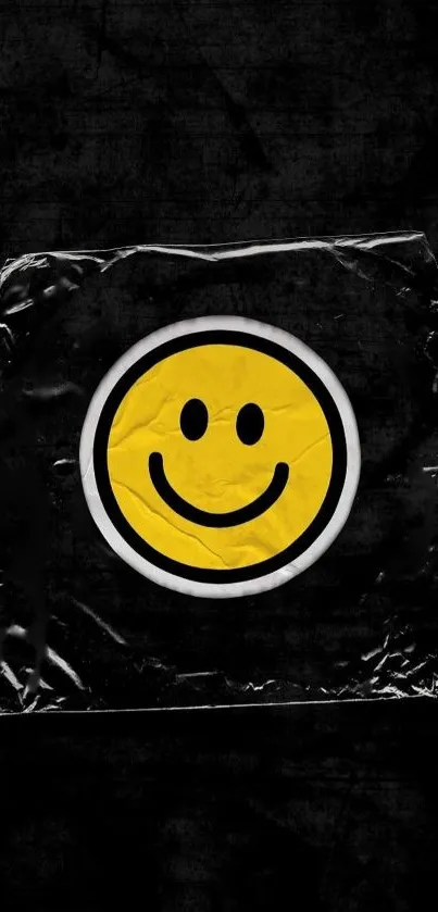 Black textured wallpaper with a yellow smiley face sticker.