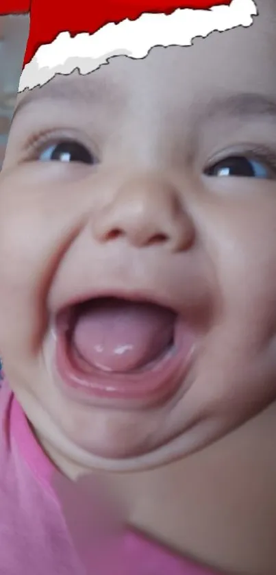 Smiling baby with Santa hat, closeup with pink tones.