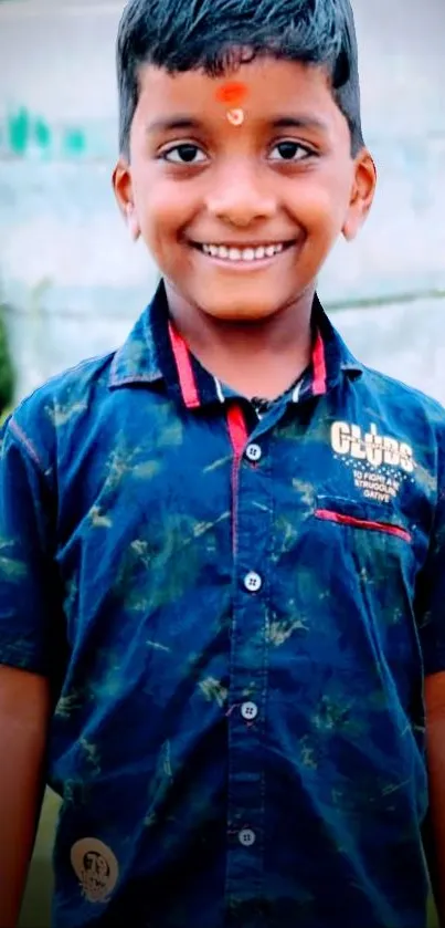 Smiling boy in a navy blue shirt against a natural background.