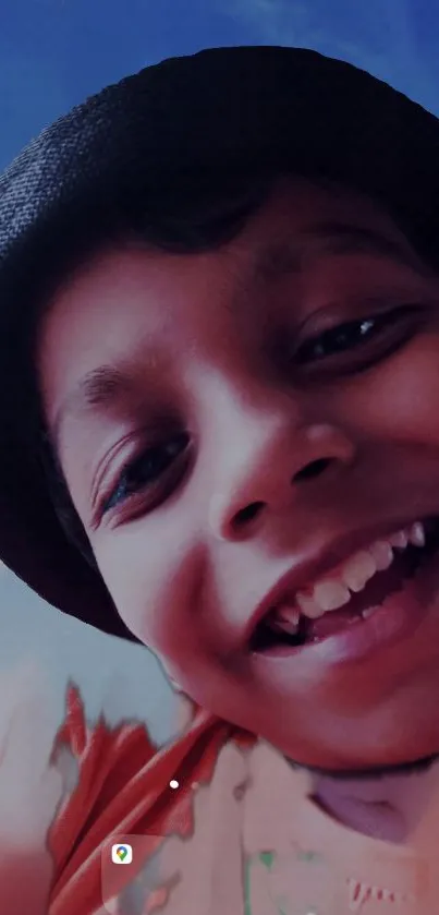 Smiling child wearing hat with blue background on phone wallpaper.