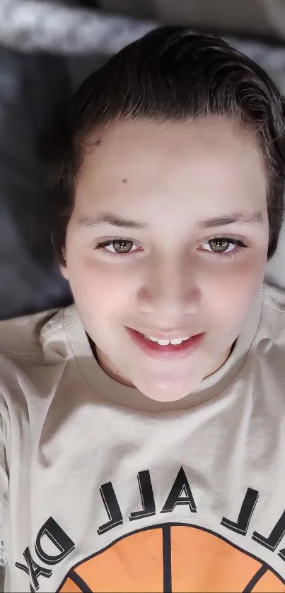 Smiling boy in casual beige shirt on bed.