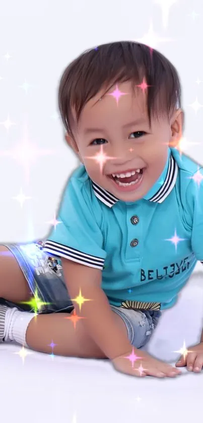 Child in blue shirt with sparkles, smiling joyfully.