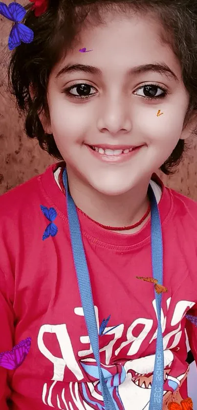 Child smiling in red shirt with headband, ideal phone wallpaper.