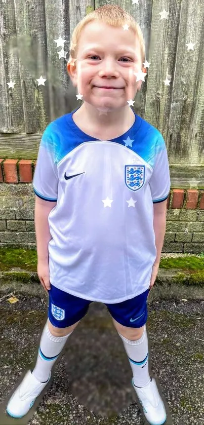 Smiling child in a blue and white soccer kit, outdoors with stars around.