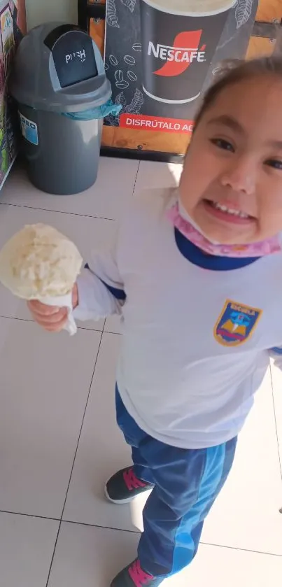 Smiling child holding ice cream indoors.