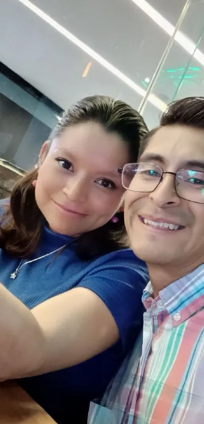 Smiling couple taking a selfie in a cafe.