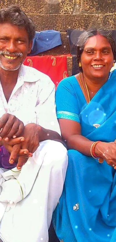 Smiling couple in vibrant traditional attire with blue dominant color.