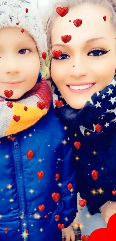 Smiling child and adult in winter gear with stars and heart.