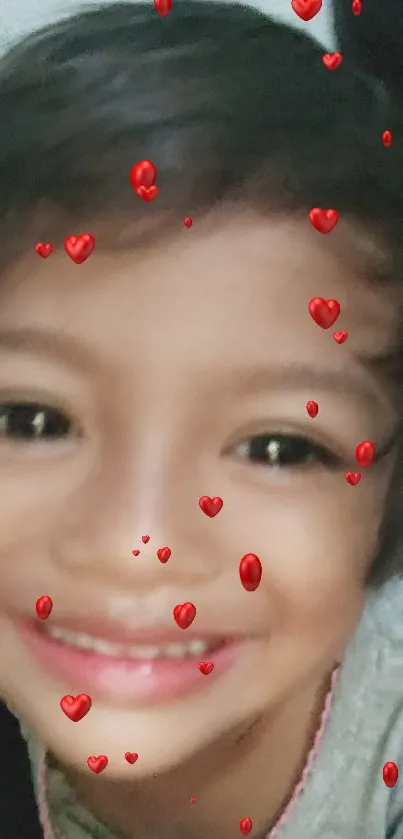 Smiling child with heart-themed filter on face.