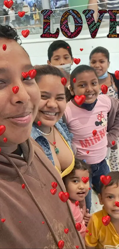 Family smiling in a mall, love decor above.