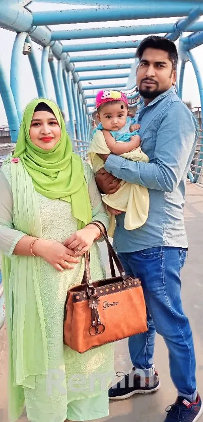 Smiling family poses on an urban bridge.