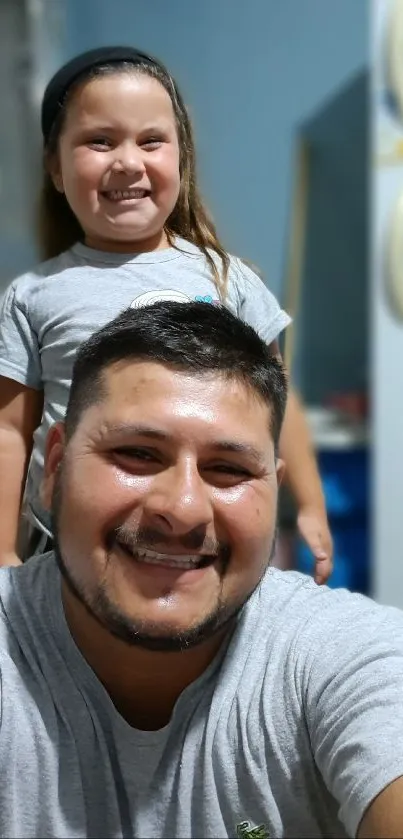 Father and daughter smiling in a casual home setting.