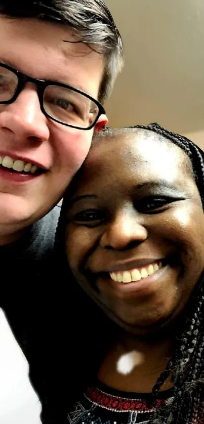 Two friends smiling brightly in a close-up portrait.