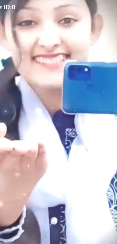 Smiling girl taking a selfie with blue phone.