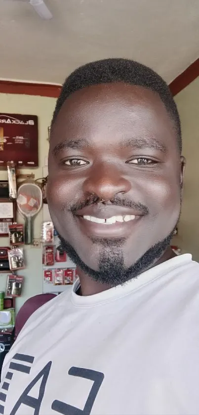 Smiling man in electronics shop with gadgets.