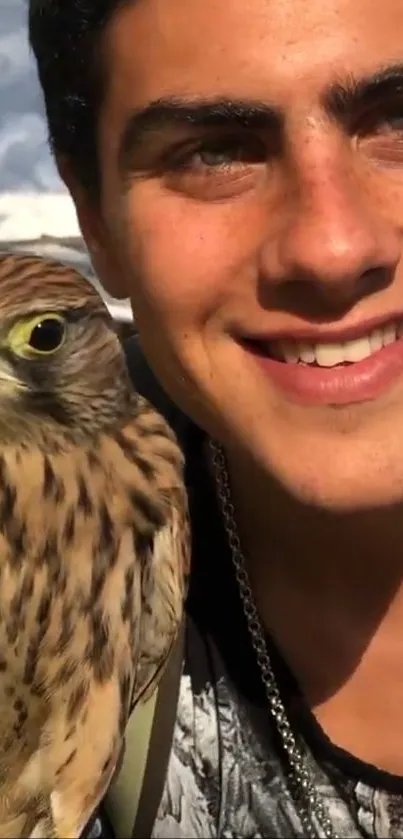 Man smiling with a falcon in a nature setting.