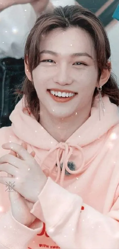 Person smiling in pastel pink hoodie, vibrant and cheerful.