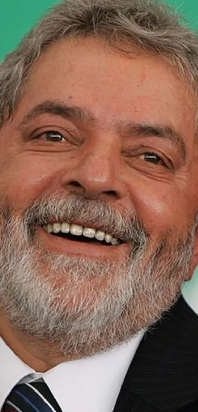 Smiling man against a bright green background in formal attire.