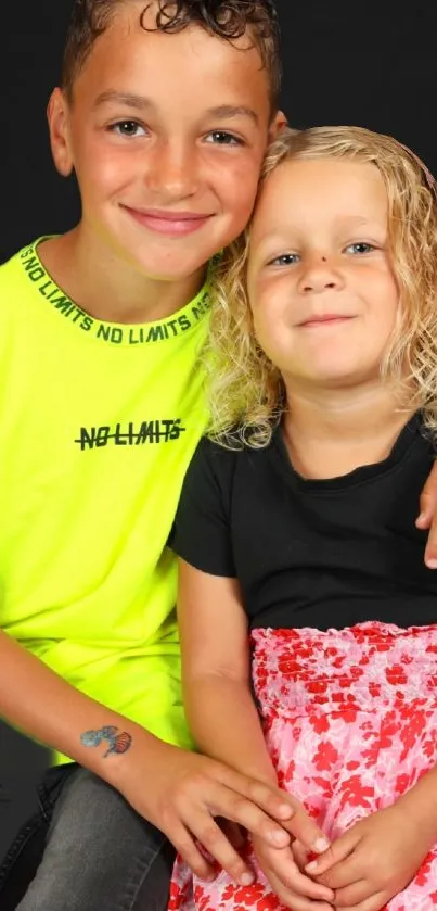 Smiling siblings in black and neon attire.