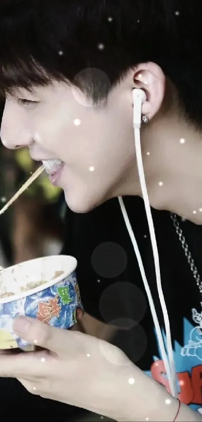 Smiling teen eats noodles, wearing earphones.