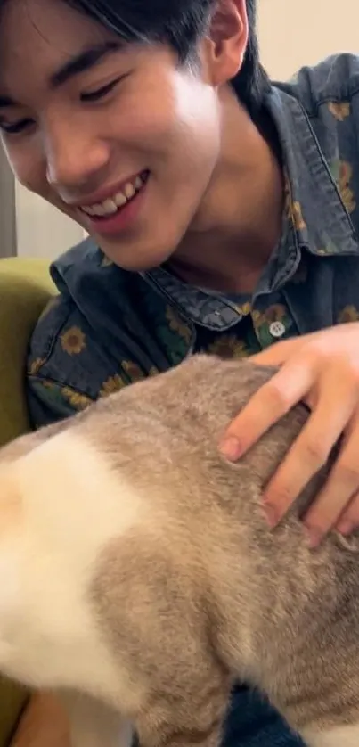 Person smiling while petting a cat on a cozy chair.