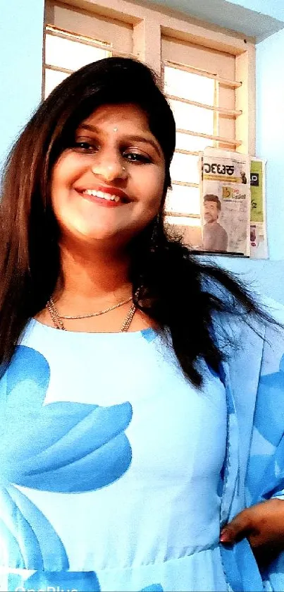 Smiling woman in blue dress indoors, looking happy and positive.